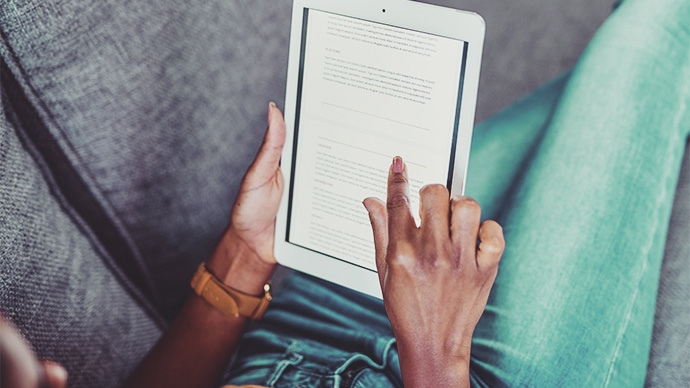 Shot of an unrecognizable woman using a digital tablet on the sofa at home
