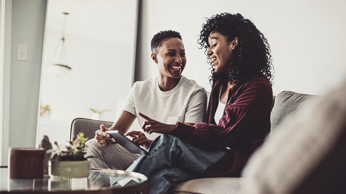 Lesbian couple at home using digital tablet