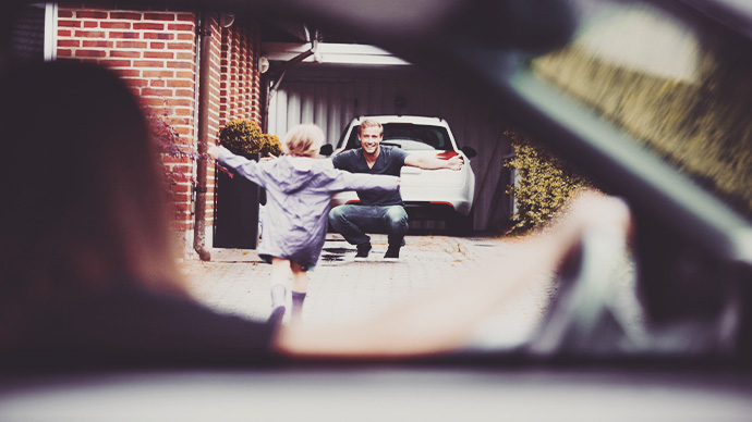 So excited to see daddy! Daughter running to father for hug in driveway