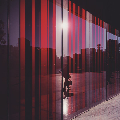 Businessperson walking past abstract glass window